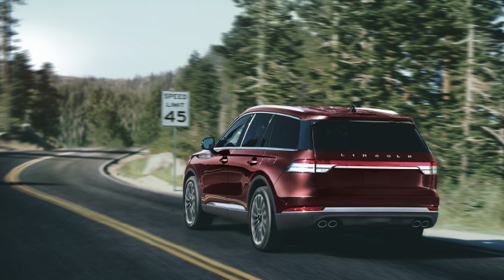 A 2024 Lincoln Aviator® SUV is being driven on a winding mountain road | Hooks Lincoln in Fort Worth TX